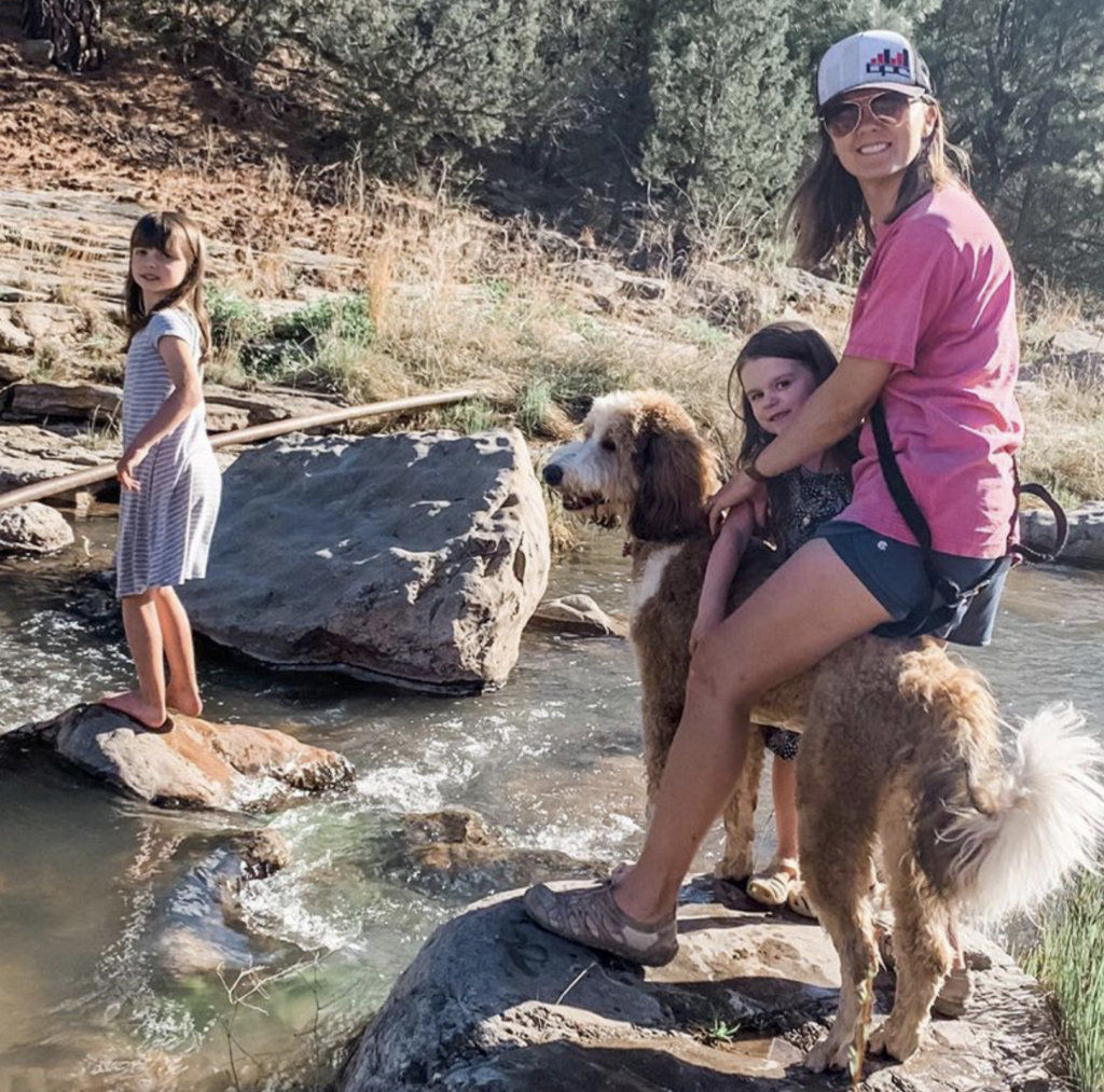 family on a hike with their bernedoodle